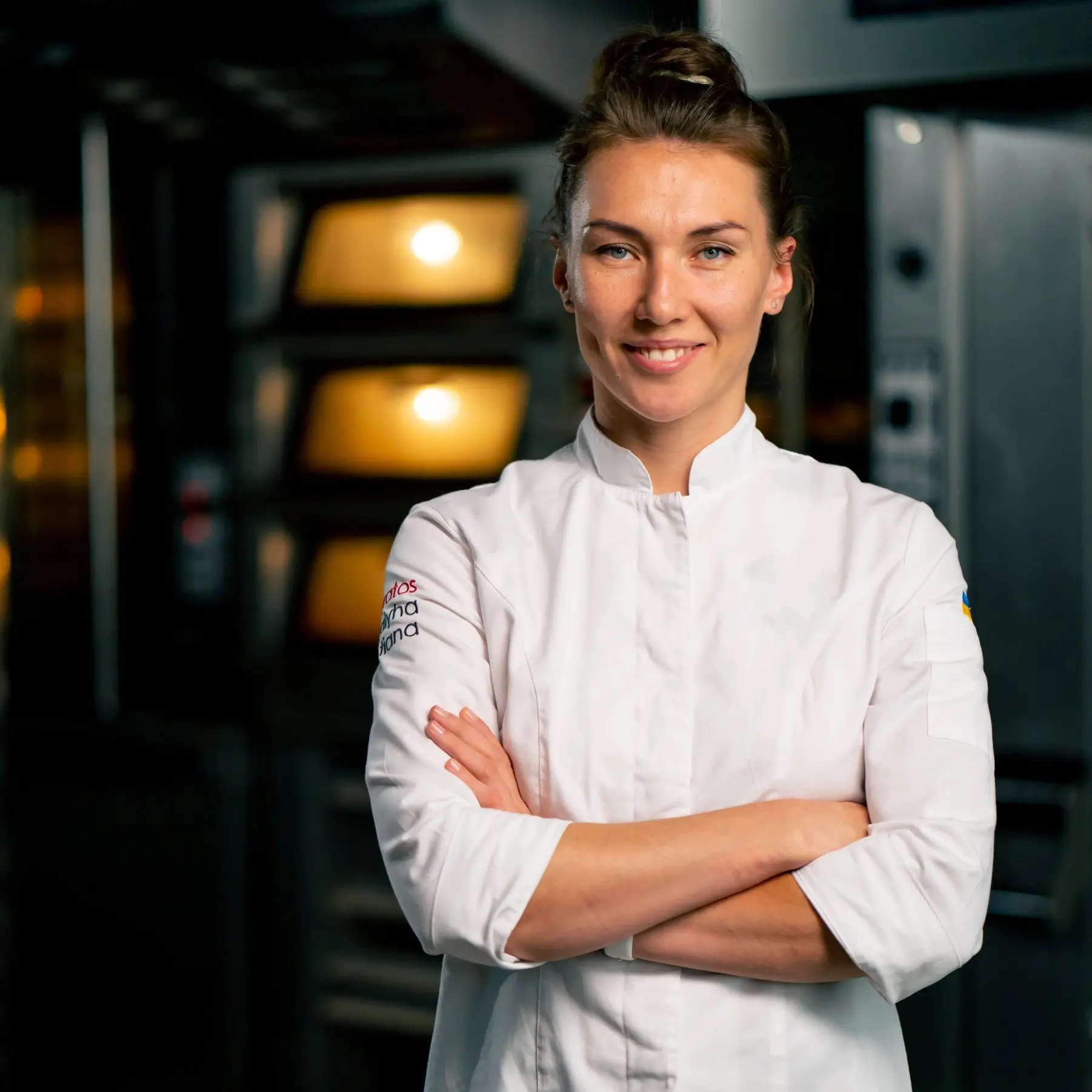 Dominika Zawadzka arranging artisan bread in a professional baking kitchen at SliceSync.