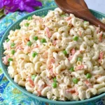 Authentic Hawaiian Macaroni Salad with peas, carrots, and creamy dressing in a serving bowl