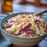 Creamy Cabbage Slaw for Burgers and BBQ 2 Creamy Cabbage Slaw with shredded cabbage, carrots, and dressing in a serving bowl