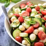 Cucumber Caprese Salad with cherry tomatoes, mozzarella balls, and fresh basil
