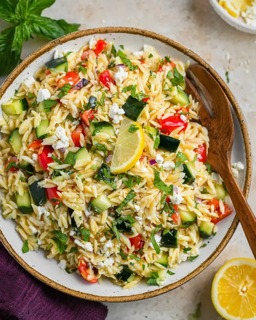 Lemon Orzo Salad with Feta, cucumber, tomatoes, herbs, and lemon slices