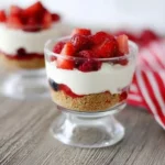 No-Bake Berry Yogurt Cheesecakes served in glass dessert cups with fresh strawberries and berries