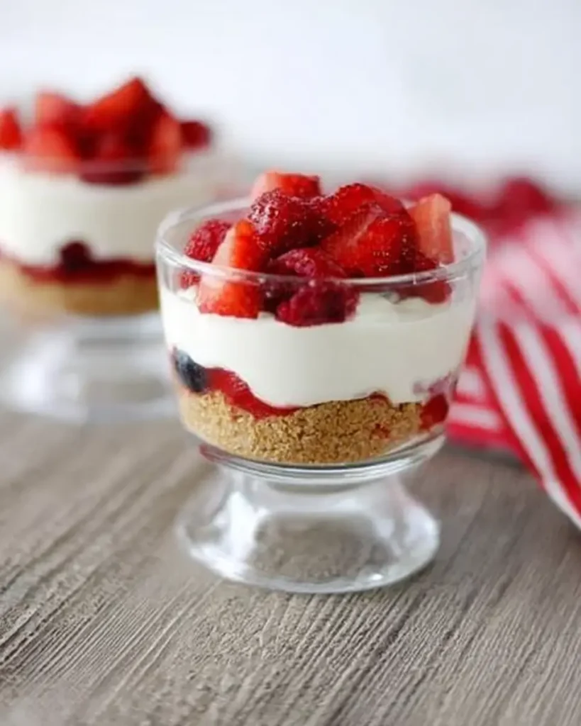No-Bake Berry Yogurt Cheesecakes served in glass dessert cups with fresh strawberries and berries