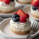 No Bake Cheesecake Cups topped with strawberries, blueberries, and raspberries on dessert plates