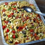 Pasta Salad for Large Crowds with rotini pasta, tomatoes, cucumbers, olives, and feta cheese