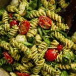 Pesto Pasta Salad with rotini pasta, cherry tomatoes, mozzarella, and basil
