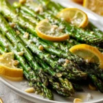 Roasted asparagus side dish with garlic, lemon, and lightly crisp edges on a serving platter.